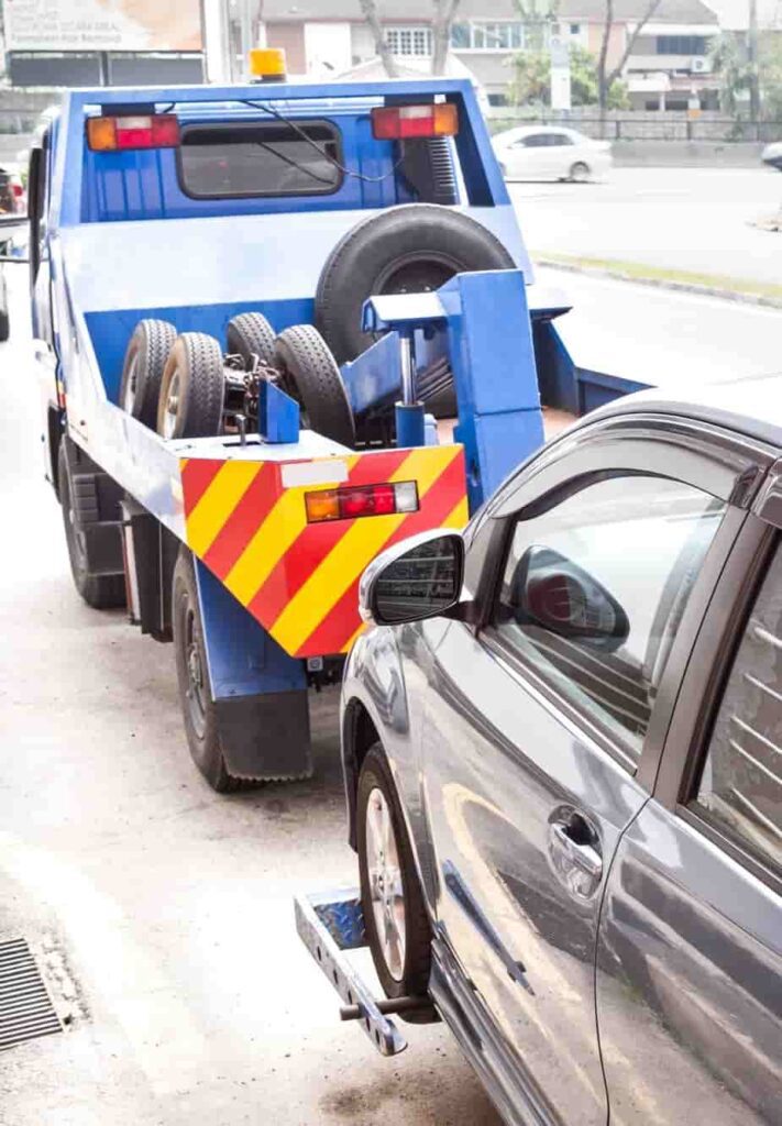Tow truck towing a broken-down car on a city street in Calgary