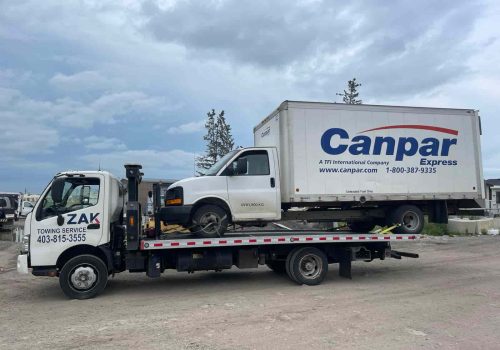 Zak Towing Service towing a Canpar Express commercial delivery truck on a flatbed tow truck in Calgary. Zak Towing specializes in safe and dependable towing for commercial vehicles, cargo vans, delive...Sorry but this string is too long !!!