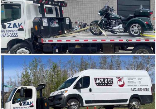 Flatbed tow truck loading a medium-duty pickup truck in Calgary by Zak Towing