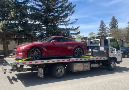 Flatbed tow truck transporting a luxury sports car in Calgary